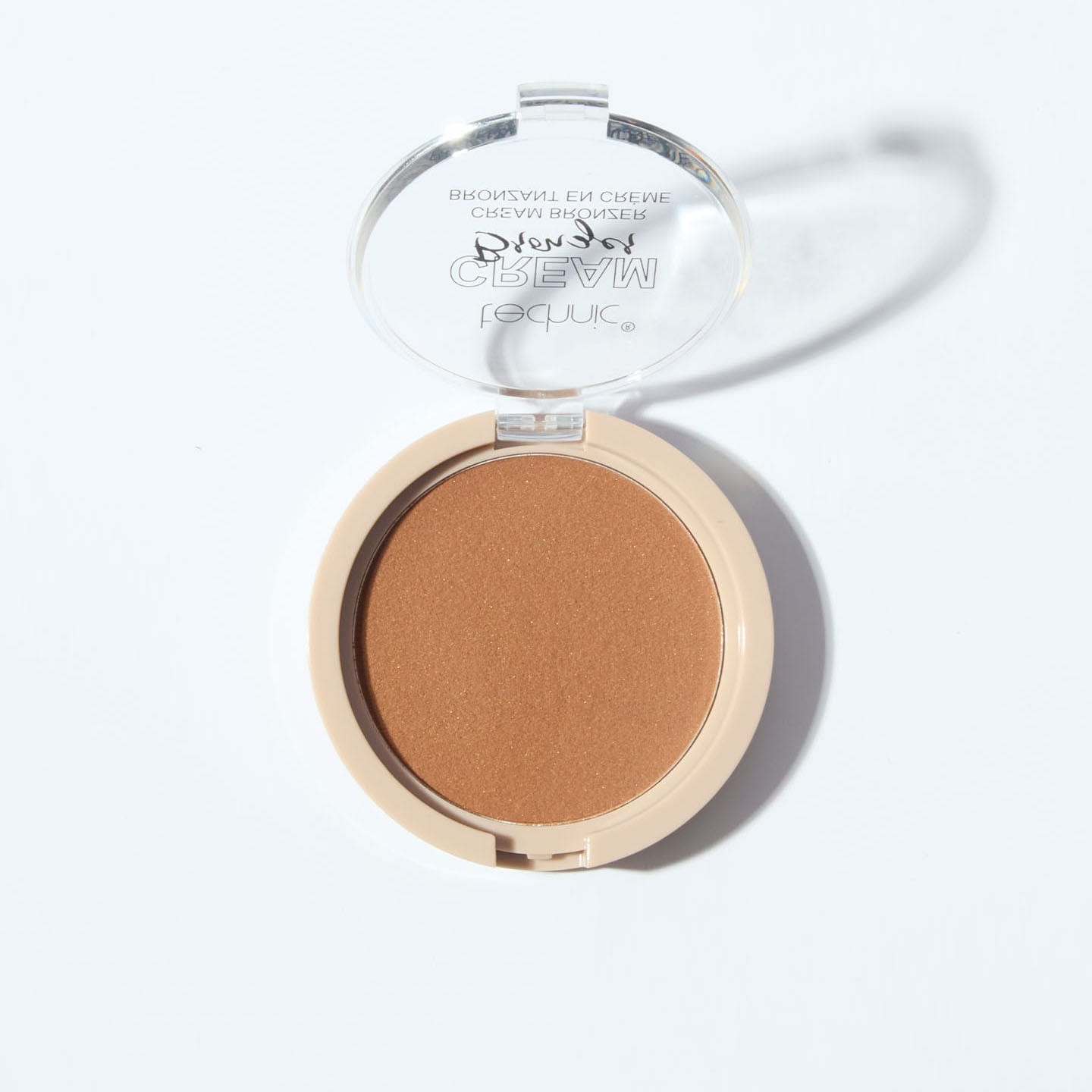 An opened cream bronzer in the shade Medium on a white background.