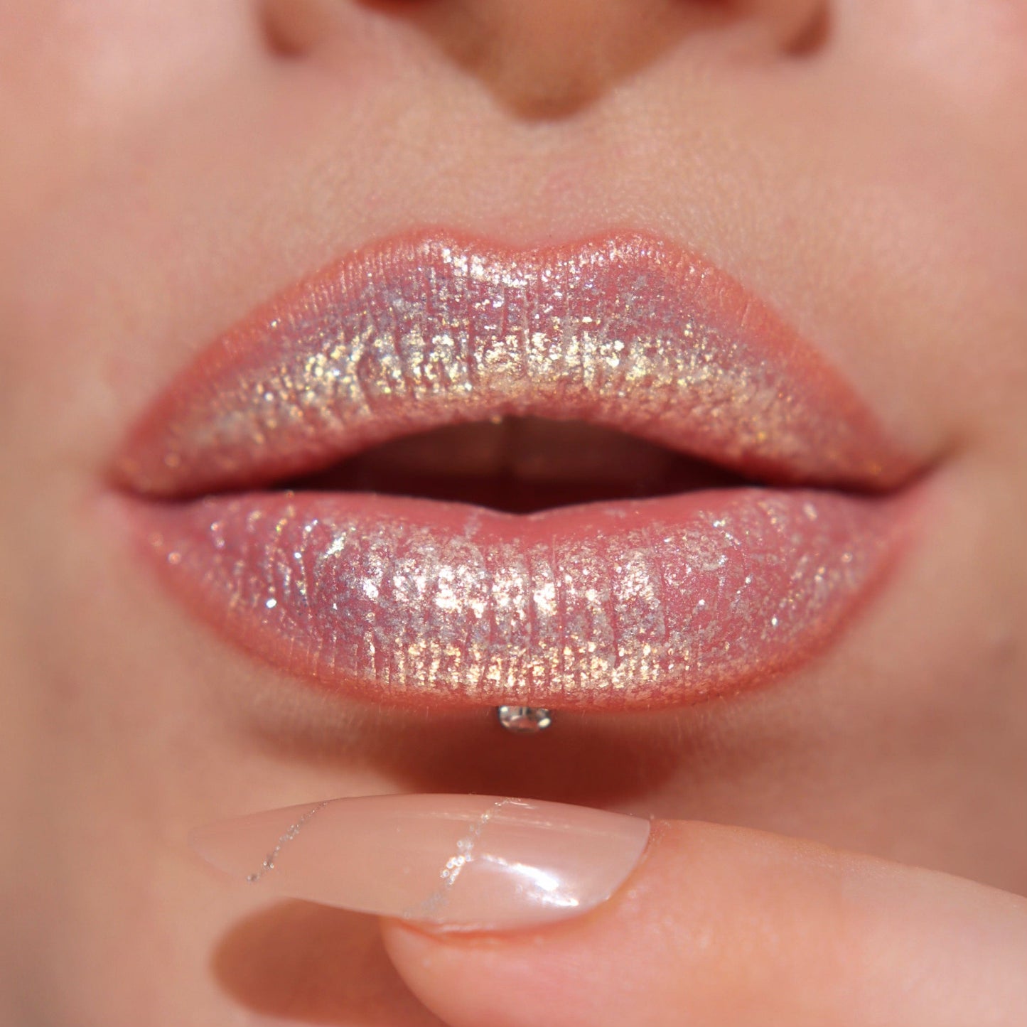 A close up of a models lips wearing the glitter gloss in he shade Gold.