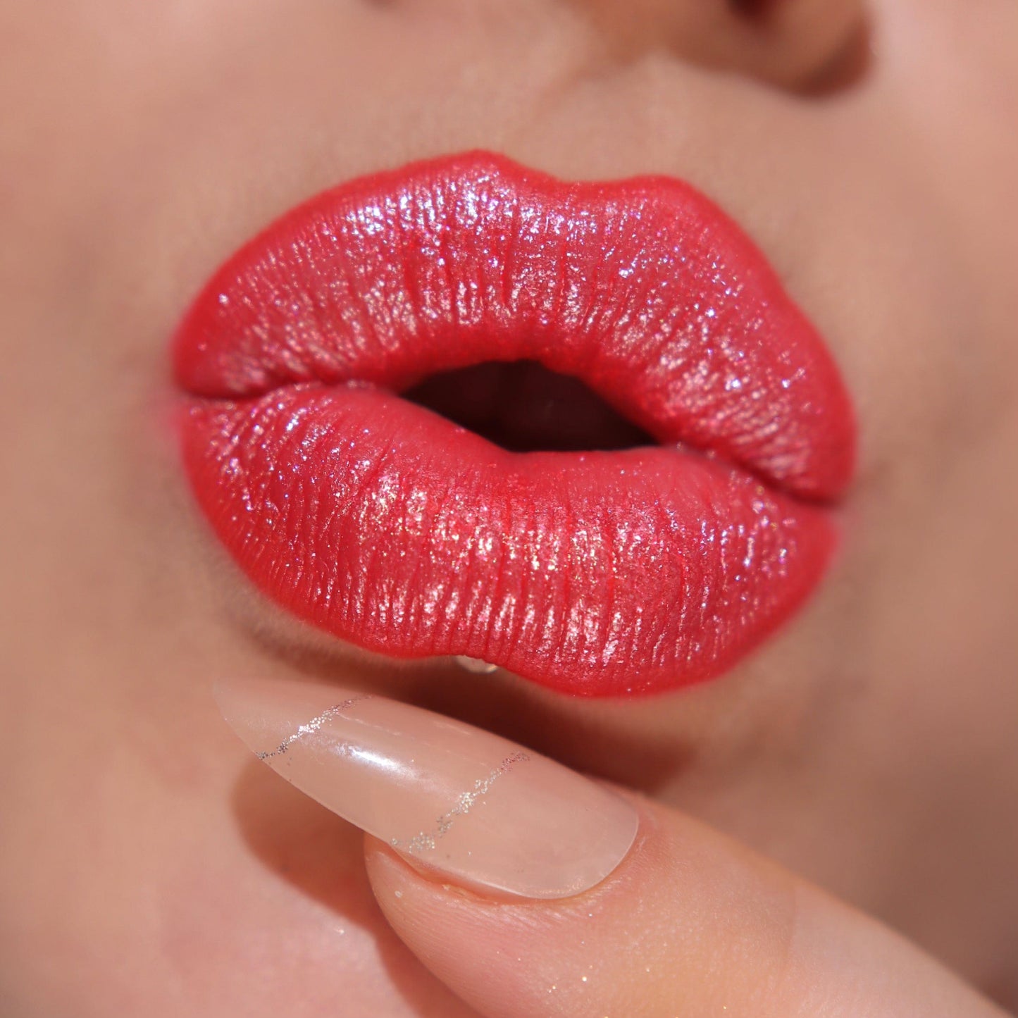 A close up of a models lips wearing the glitter gloss in he shade Red.