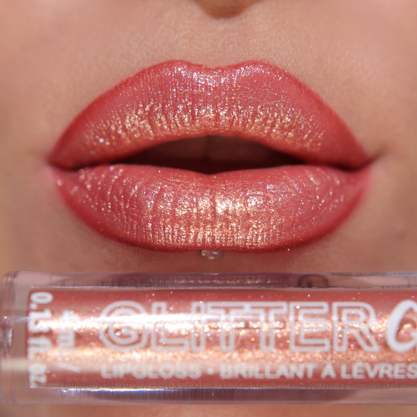 A close up of a models lips wearing the glitter gloss in he shade Rose Gold.